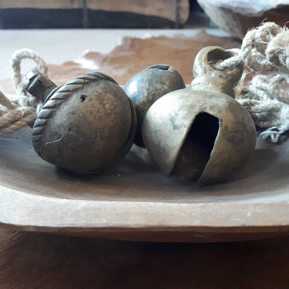 Koeienbellen op oud houten schaaltje